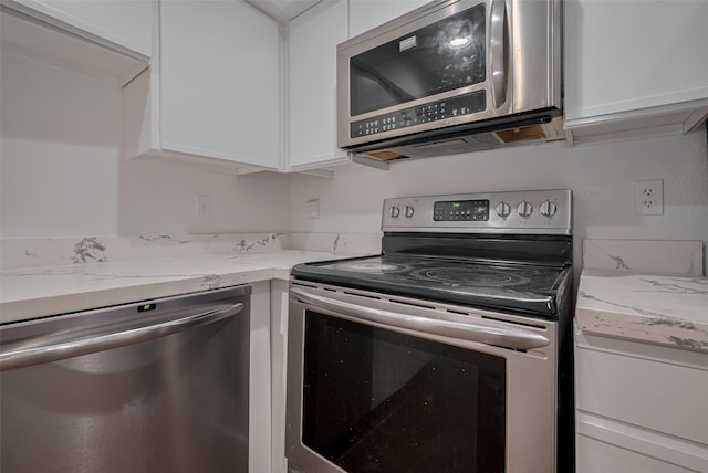 16800 Sugar Pines Dr Unit D28, Houston, TX 77090 - kitchen featuring white cabinets, light stone counters, and stainless steel appliances