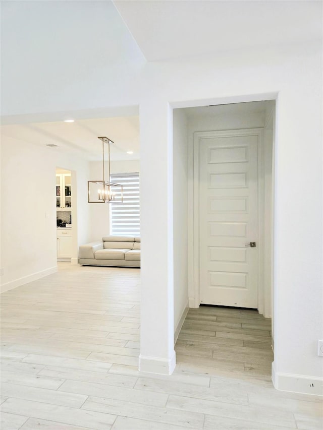 1902 Longcroft Ln, Katy, TX 77493 - hallway with baseboards, light wood-type flooring, and a chandelier