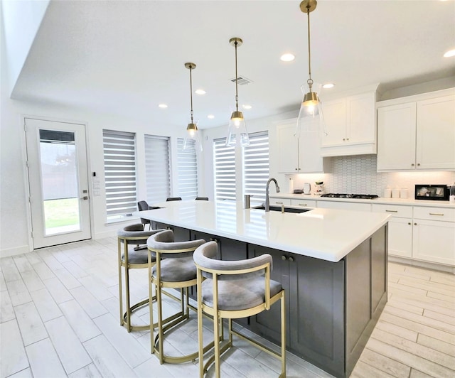 1902 Longcroft Ln, Katy, TX 77493 - kitchen with a sink, gas cooktop, decorative backsplash, light countertops, and recessed lighting