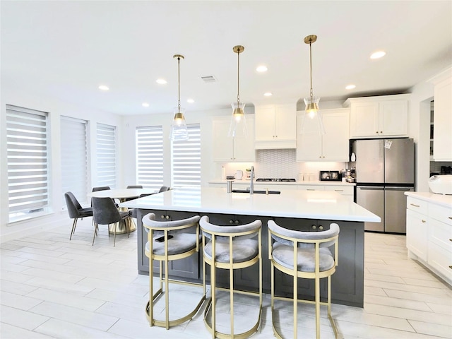 1902 Longcroft Ln, Katy, TX 77493 - kitchen featuring freestanding refrigerator, backsplash, light countertops, a sink, and a kitchen breakfast bar