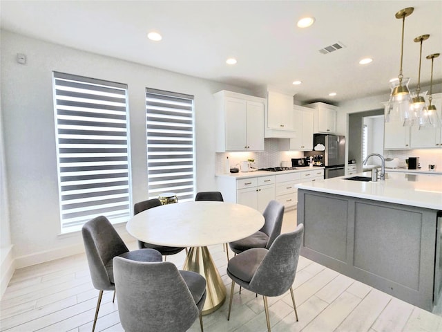1902 Longcroft Ln, Katy, TX 77493 - kitchen with a sink, freestanding refrigerator, light countertops, white cabinets, and pendant lighting
