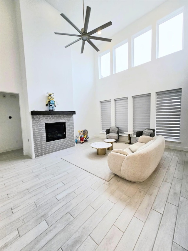 1902 Longcroft Ln, Katy, TX 77493 - living room featuring a towering ceiling, a ceiling fan, a brick fireplace, and wood finished floors