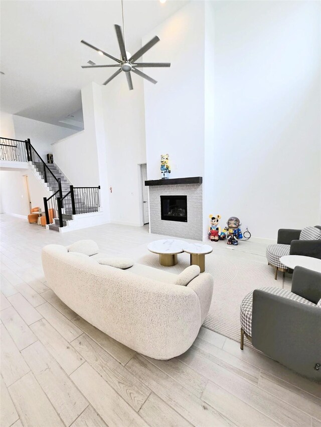 1902 Longcroft Ln, Katy, TX 77493 - living room with a glass covered fireplace, wood finished floors, stairway, a ceiling fan, and a high ceiling
