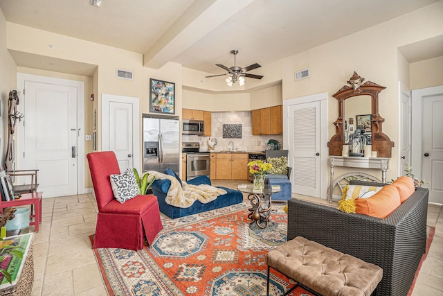 living area featuring visible vents, a ceiling fan, stone tile floors, and beamed ceiling
