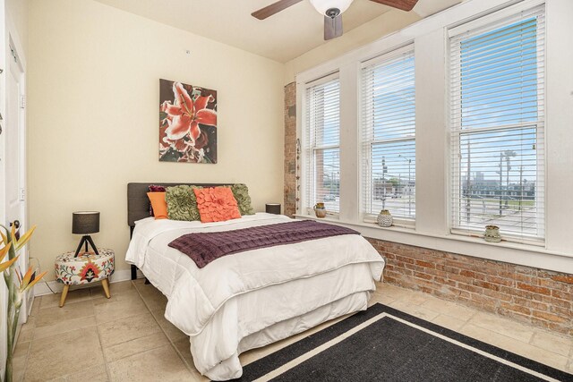 bedroom with a ceiling fan and stone tile flooring
