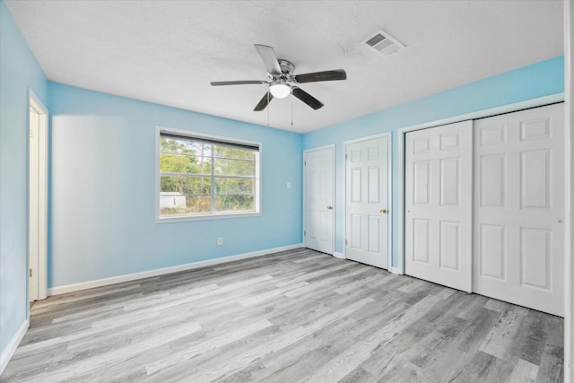 636 S Fm 356, Onalaska, TX 77360 - unfurnished bedroom with visible vents, baseboards, multiple closets, and wood finished floors