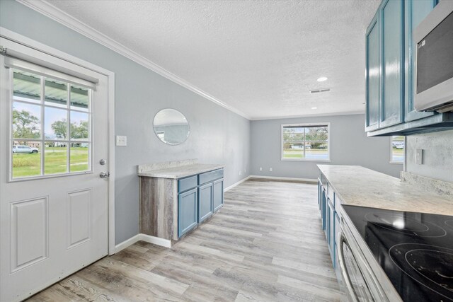 636 S Fm 356, Onalaska, TX 77360 - kitchen with light countertops, appliances with stainless steel finishes, blue cabinetry, and a textured ceiling
