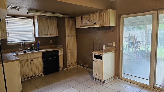 kitchen featuring black dishwasher, a sink, light tile patterned floors, and visible vents