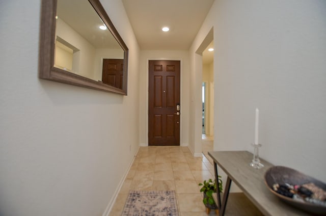doorway featuring light tile patterned floors, baseboards, and recessed lighting