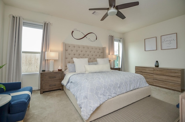 carpeted bedroom with visible vents and ceiling fan