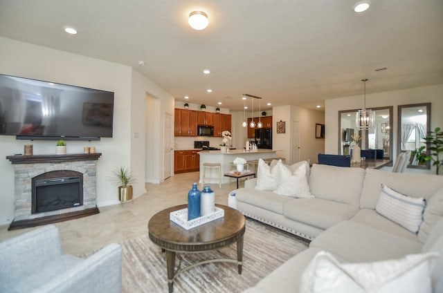 living room with baseboards, a fireplace, recessed lighting, and a notable chandelier