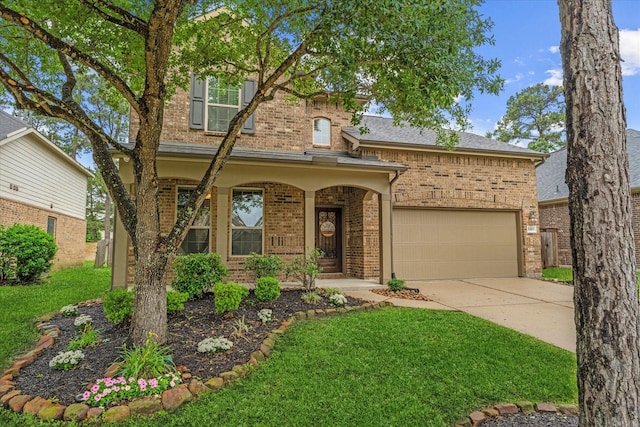 traditional-style house with brick siding, an attached garage, driveway, and a front lawn