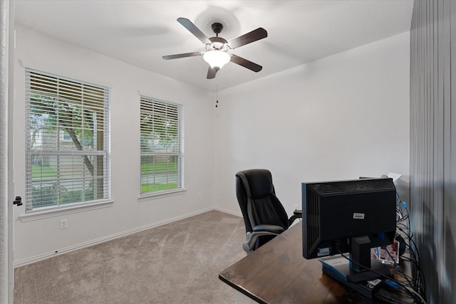office area with carpet, a ceiling fan, and baseboards
