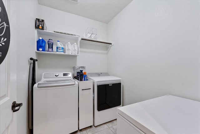 clothes washing area featuring washing machine and clothes dryer and light tile patterned flooring
