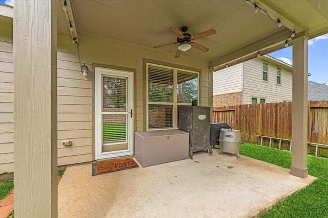 doorway to property featuring ceiling fan, a patio area, and fence