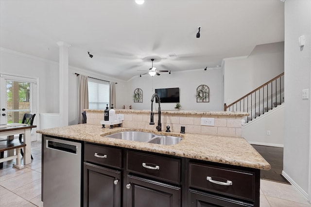 kitchen featuring stainless steel dishwasher, a sink, ornamental molding, an island with sink, and healthy amount of natural light