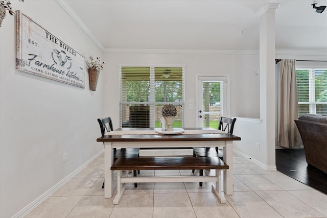 dining space featuring healthy amount of natural light, ornamental molding, light tile patterned flooring, and baseboards