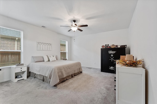 bedroom featuring light carpet, ceiling fan, and baseboards