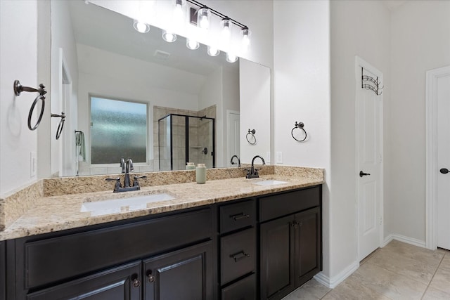bathroom featuring a shower stall, double vanity, and tile patterned flooring