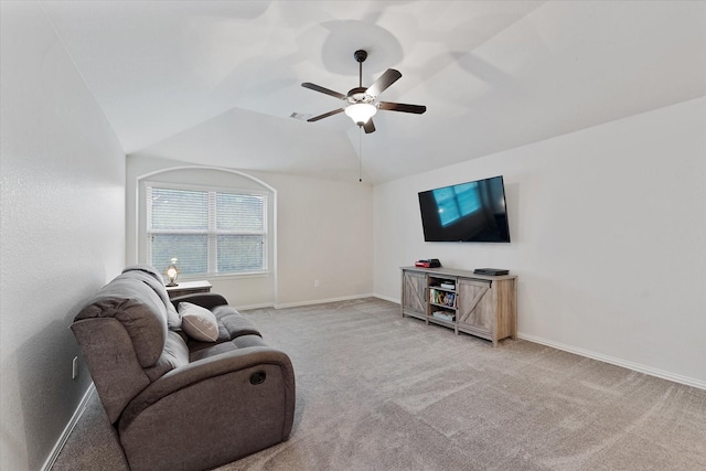 living area featuring a ceiling fan, vaulted ceiling, light carpet, and baseboards