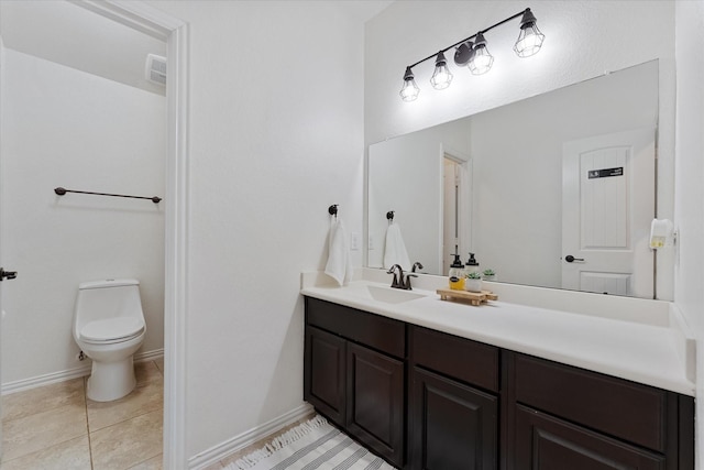 bathroom featuring vanity, tile patterned floors, baseboards, and toilet