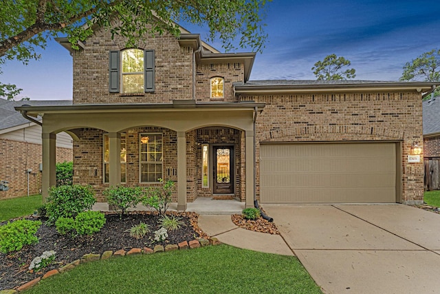 traditional home with brick siding, driveway, a garage, and a porch