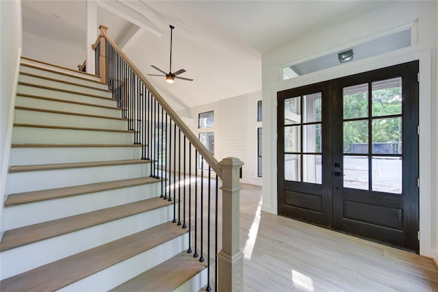 foyer entrance with ceiling fan, light wood-type flooring, stairs, french doors, and lofted ceiling