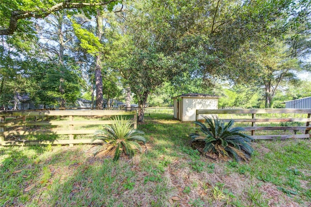 view of yard featuring a storage shed, fence private yard, and an outbuilding