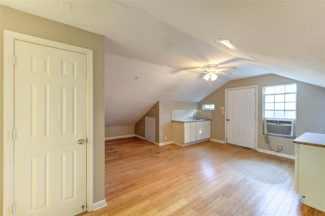 bonus room featuring baseboards, light wood-type flooring, ceiling fan, and vaulted ceiling
