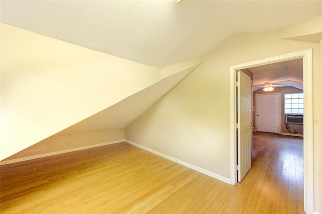 additional living space featuring lofted ceiling, wood finished floors, cooling unit, and baseboards