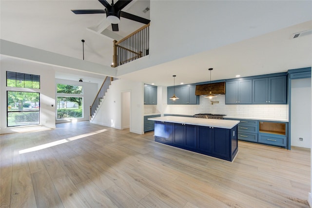 kitchen with blue cabinets, light wood-type flooring, open floor plan, and light countertops