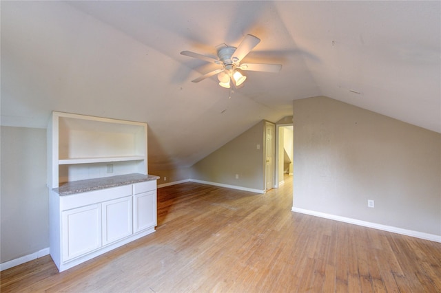 bonus room with lofted ceiling, ceiling fan, baseboards, and light wood-style floors