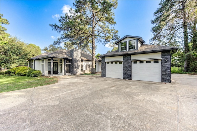 view of front of house with stone siding, french doors, and a garage