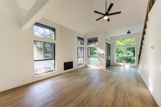 unfurnished living room featuring ceiling fan, wood finished floors, and plenty of natural light