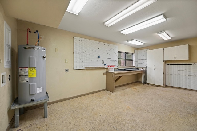 interior space with a workshop area, water heater, and baseboards