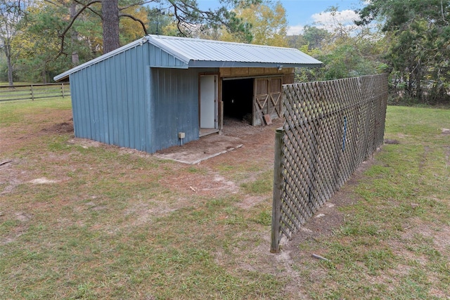 view of outbuilding with fence and an outbuilding