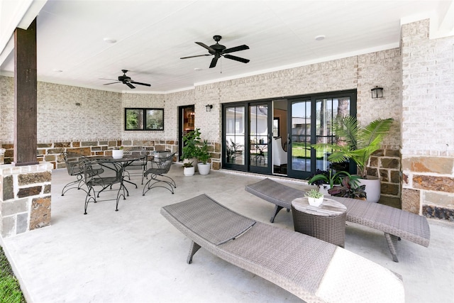 view of patio / terrace with outdoor dining area, a ceiling fan, and french doors