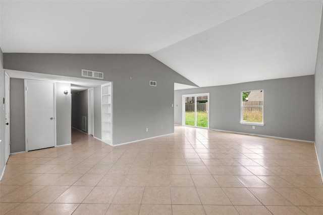 unfurnished room featuring light tile patterned floors, visible vents, baseboards, vaulted ceiling, and built in features