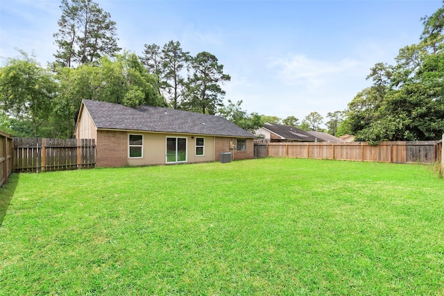 back of house with a lawn and a fenced backyard