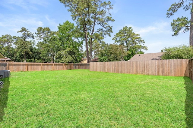 view of yard with a fenced backyard and central air condition unit