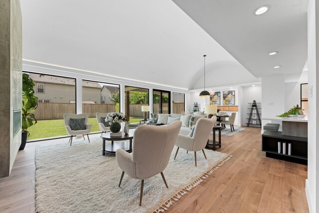 living room featuring light wood-style floors, vaulted ceiling, and recessed lighting