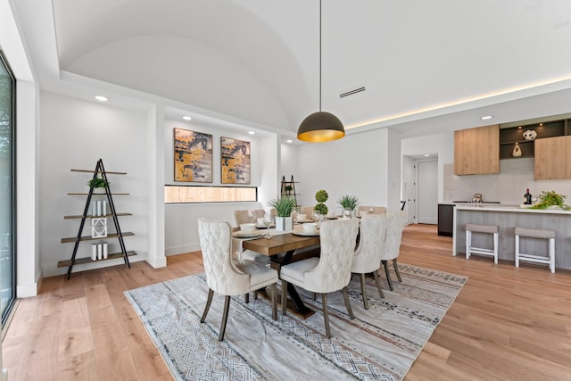 dining area with visible vents, lofted ceiling, light wood-style floors, baseboards, and recessed lighting