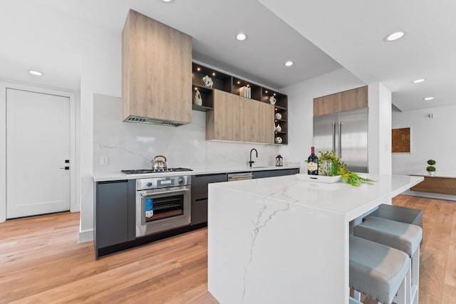 kitchen featuring a kitchen island, modern cabinets, open shelves, light wood-style floors, and stainless steel appliances