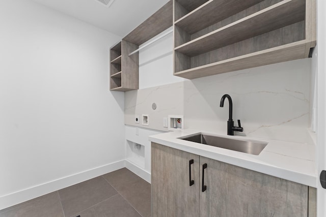 washroom with washer hookup, laundry area, a sink, electric dryer hookup, and dark tile patterned floors