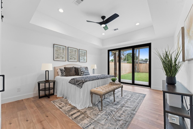 bedroom with access to outside, a raised ceiling, baseboards, and visible vents