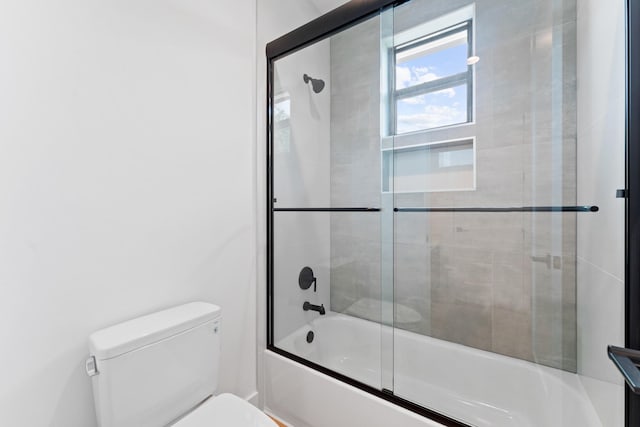 bathroom with enclosed tub / shower combo and toilet