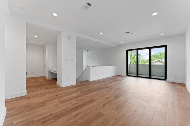 unfurnished living room with recessed lighting, baseboards, and light wood-type flooring