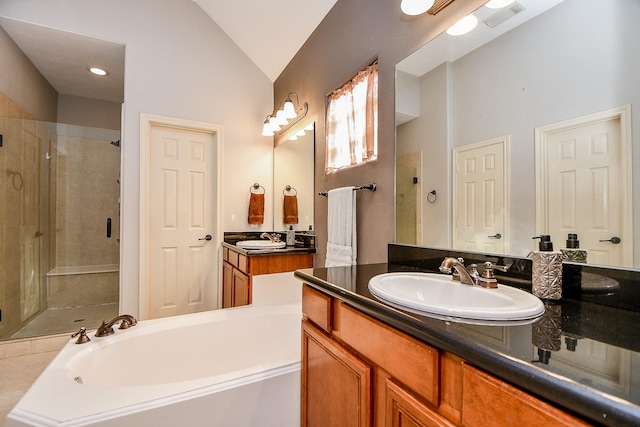 1708 Aden Mist Dr, Houston, TX 77003 - bathroom featuring a stall shower, a garden tub, lofted ceiling, and two vanities