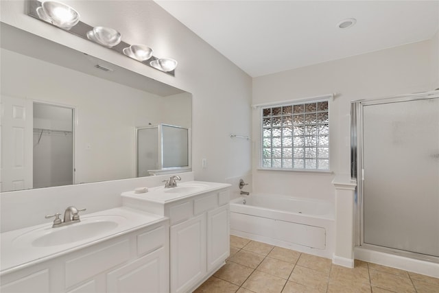 full bathroom featuring a sink, a shower stall, tile patterned floors, double vanity, and a garden tub