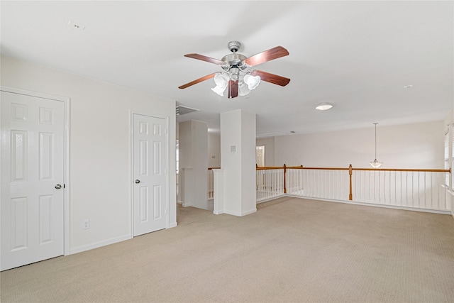spare room with ceiling fan, baseboards, visible vents, and light carpet